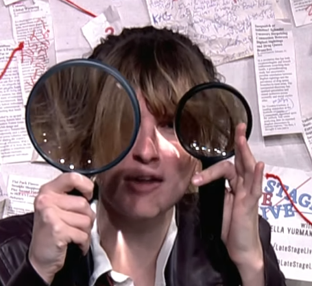 woman holding two magnifying glasses to her face.